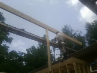Carpenter setting a ridge beam over a new addition frame — Ice Dam Removal by Roofing Brothers in Hayden