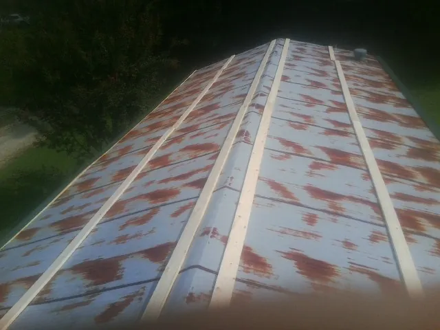 Rusted metal roof panels with new wood purlins before replacement — Storm Damage Roof Repair in Hayden by Roofing Brothers
